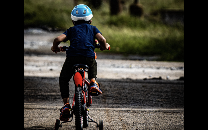 A child is shown riding a bicycle.
