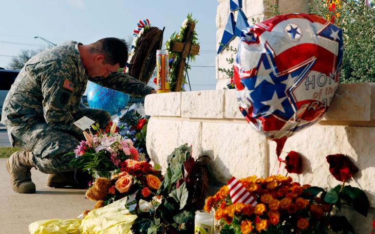 U.S. Army Specialist Robert Orcutt prays near a makeshift memorial for victims of the shootings at Fort Hood Army post in Fort Hood on Nov. 9, 2009.