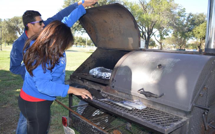 Emily Banda and Henry Luna check on their brisket. (LIVE! Photo by Lauren Lopez)