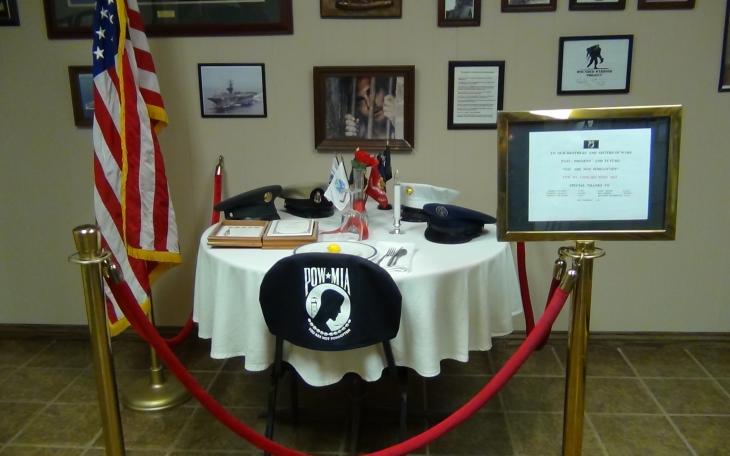 Various awards, medals and photographs populate the wall space, and the POW MIA chair is focused upon (LIVE! photo by Cheyenne Benson)