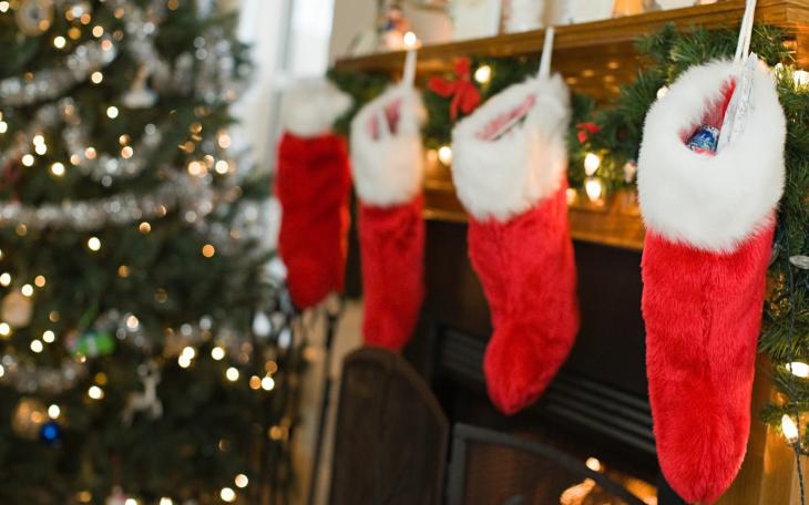 Four stockings hang over the fireplace (photo courtesy of wallpoper.com)