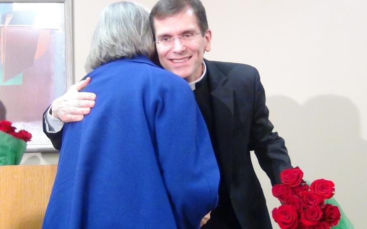 Michael Sis hugs a woman on Thursday morning after welcoming his new flock. (LIVE! Photo by Cheyenne Benson)