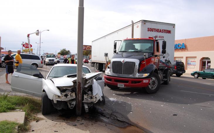 A semi-truck remains untouched in the inside lane, having pulled into the outer lane causing a compact car to swerve and hit a light pole. (LIVE! Photo by Chelsea Schmid)