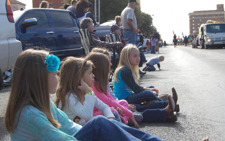 Children wait in anticipation as the next float approaches in the rodeo parade. (LIVE! Photo by Chelsea Schmid)