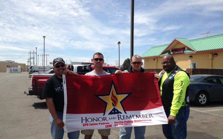 Johnny Padron (Jaime Padron's brother), Sergeant Matt Baldwin, Officer Brian Bylsma and former officer Sean Fullerton hold up a flag that will fly next to Jaime's bike on the 1,000 mile ride Saturday. (LIVE! Photo/Chelsea Schmid)