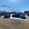 Emergency responders, including firefighters and paramedics, assess the scene of a collision involving a black Escalade at the intersection of South Chadbourne Street and East Avenue L in San Angelo.