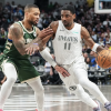 Kyrie Irving of the Dallas Mavericks drives past Damian Lillard of the Milwaukee Bucks