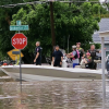 Police are seen in a rescue boat at the intersection of Koberlin and Archer streets after heavy flooding Friday, July 4, 2025.