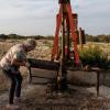 Jackie Chesnutt props up a sign next to a leaking oil well operated by CORE Petro on her property near Knickerbocker on Nov. 18, 2025.