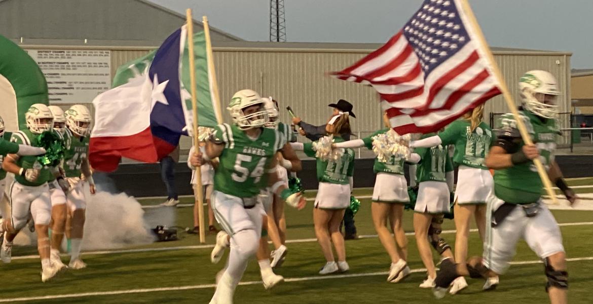 The Wall Hawks football team charges onto the field before its first-round playoff game with Anthony on Friday, Nov. 15, 2024.