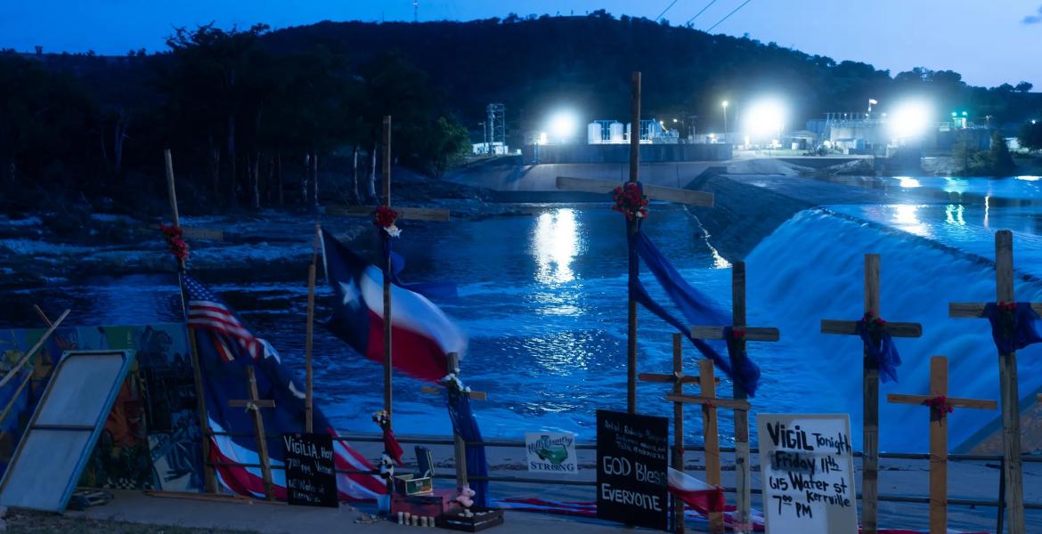 Crosses honoring the victims of the Hill Country floods, seen on July 11, 2025, were erected by artist Roberto Marquez next to the Guadalupe River in Guadalupe Park. Search efforts were suspended Sunday amid new warnings of potential flash flooding in the region. Storms on Sunday brought more floods across Central and North Texas, leading to rescues and evacuations in several counties. Credit: