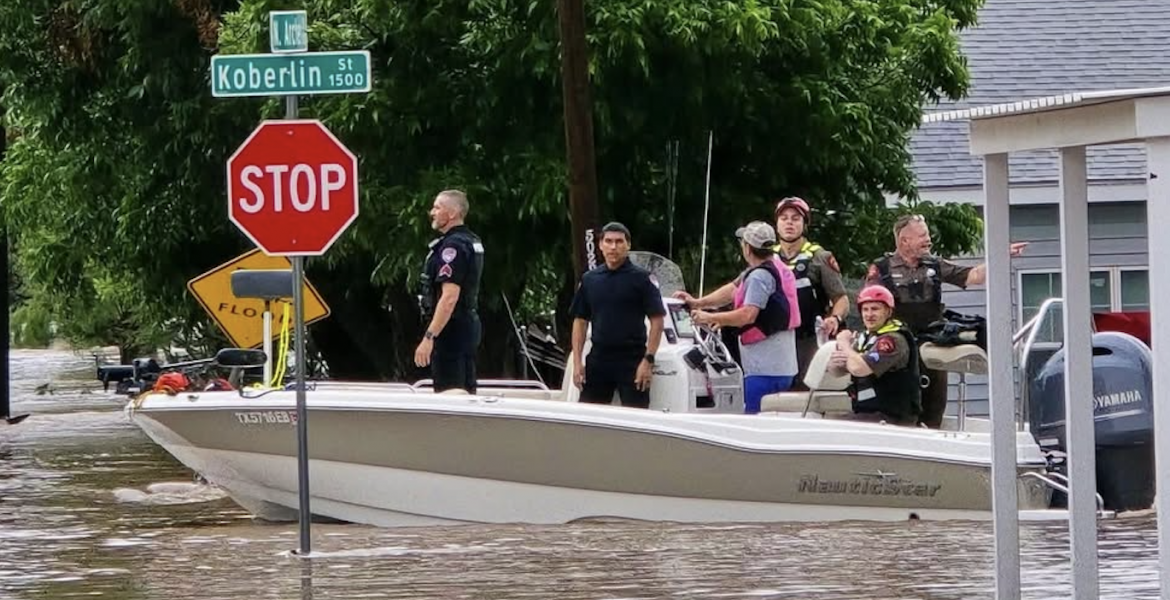 Police are seen in a rescue boat at the intersection of Koberlin and Archer streets after heavy flooding Friday, July 4, 2025.