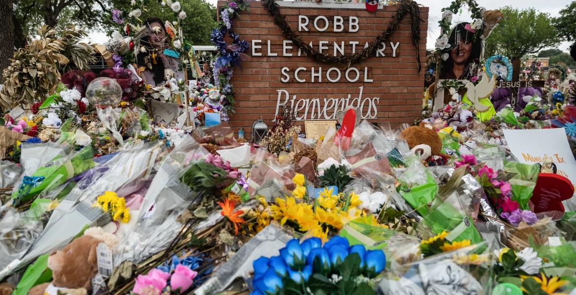 Hundreds of flowers, toys, and candles surround the crosses in memorial of the 21 victims of the Robb Elementary school shooting at Robb Elementary in 2022. Credit: