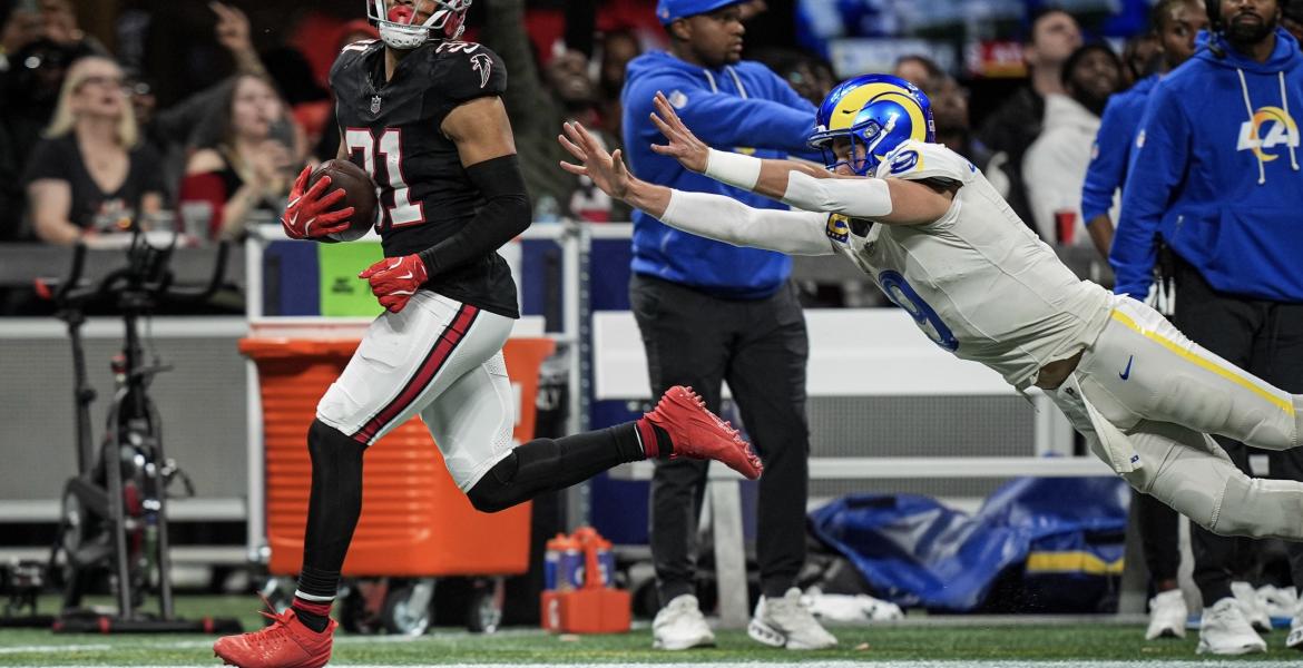 LA Rams' Matt Stafford dives at Atlanta's Xavier Watts after throwing an interception.
