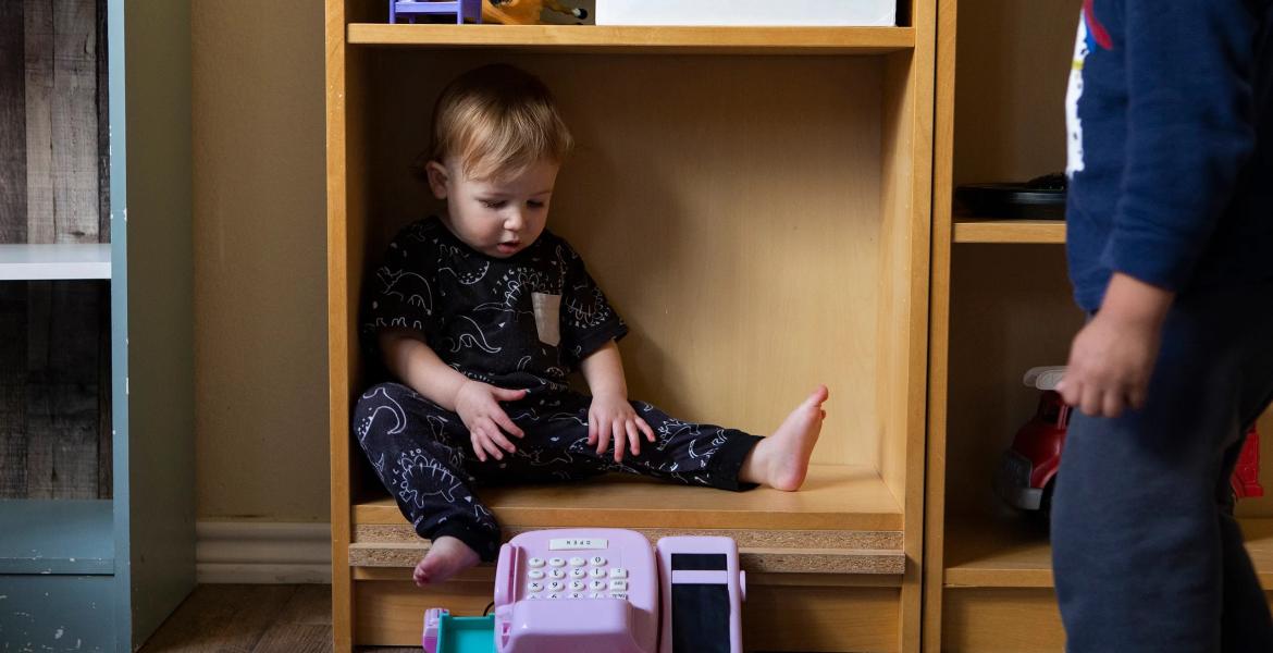 A child sits in a bookshelf at Kid's Castle Family Daycare and Preschool in Pflugerville in 2022.