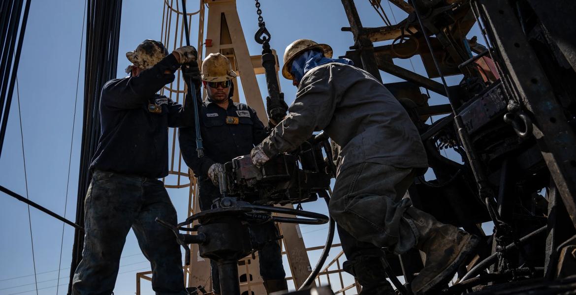 A service rig crew pulls sucker rods from an oil and gas well as they work to bring a downhole pumping unit to the surface on Aug. 14, 2024, in West Odessa.