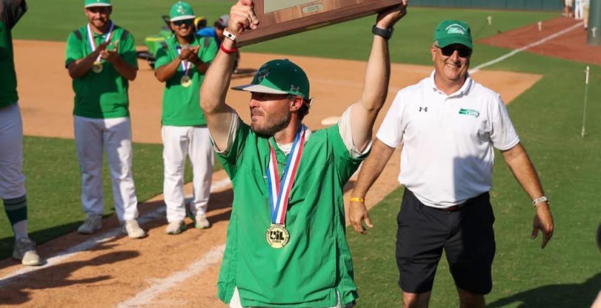 Wall baseball coach Jeremy Gordon hoists the trophy after the Hawks' state-title win over Thrall in 2025.