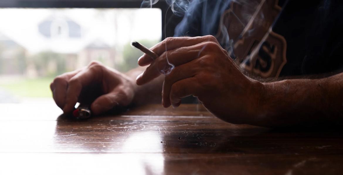 A man smokes a joint rolled from legal hemp flower in Onalaska on June 15, 2025.