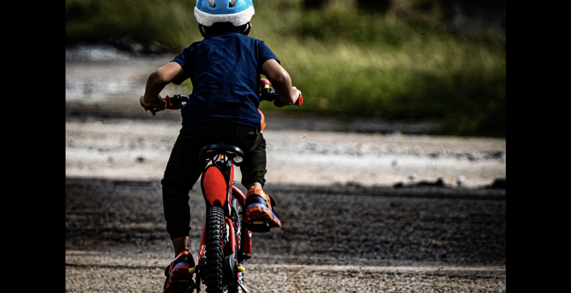 A child is shown riding a bicycle.