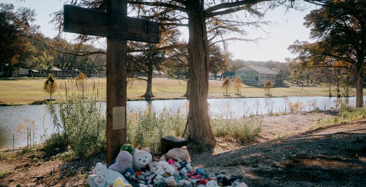 A cross honoring the victims of the July 4, 2025, flood stands in front of Camp Mystic across the Guadalupe River on Nov. 21, 2025.