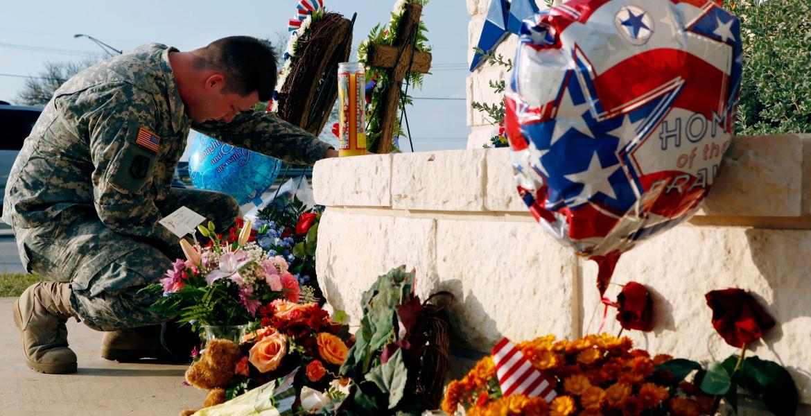 U.S. Army Specialist Robert Orcutt prays near a makeshift memorial for victims of the shootings at Fort Hood Army post in Fort Hood on Nov. 9, 2009.