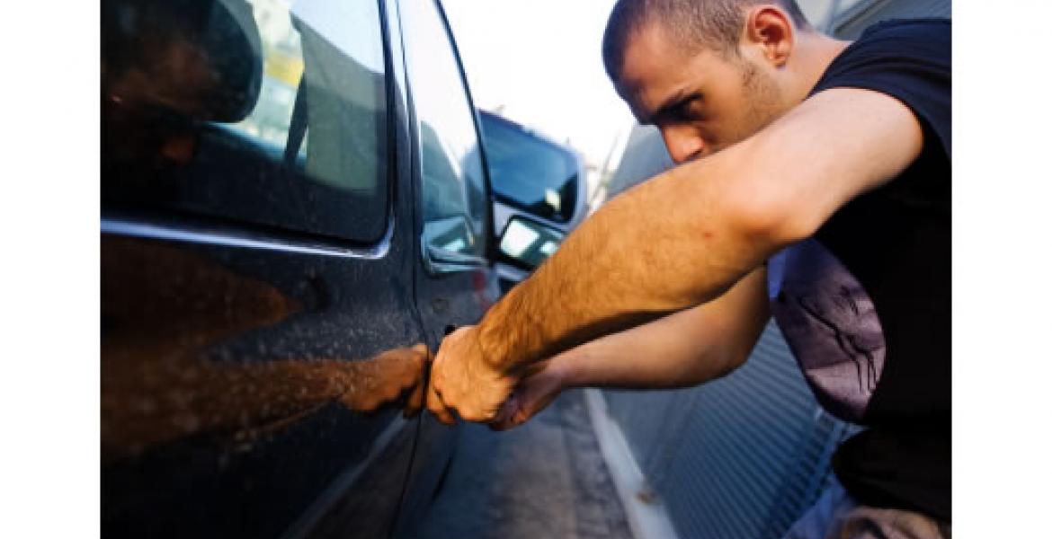 A thief prepares to break into a car (photo courtesy of naylornetwork.com)